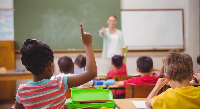 Pupils raising their hands during class